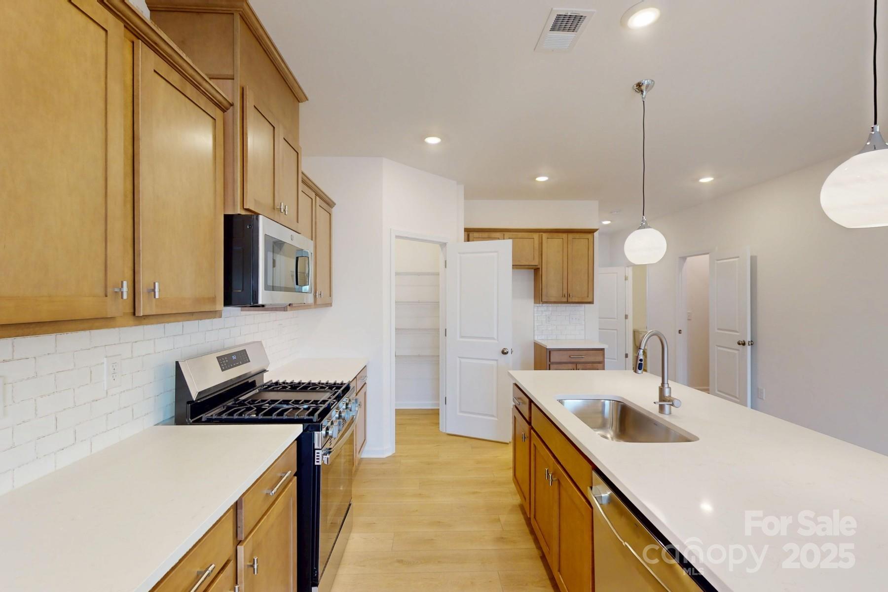 1018 Overbrook Place Wingate, NC 28174 - Photo 8 of 23 a kitchen with a stove sink and a refrigerator
