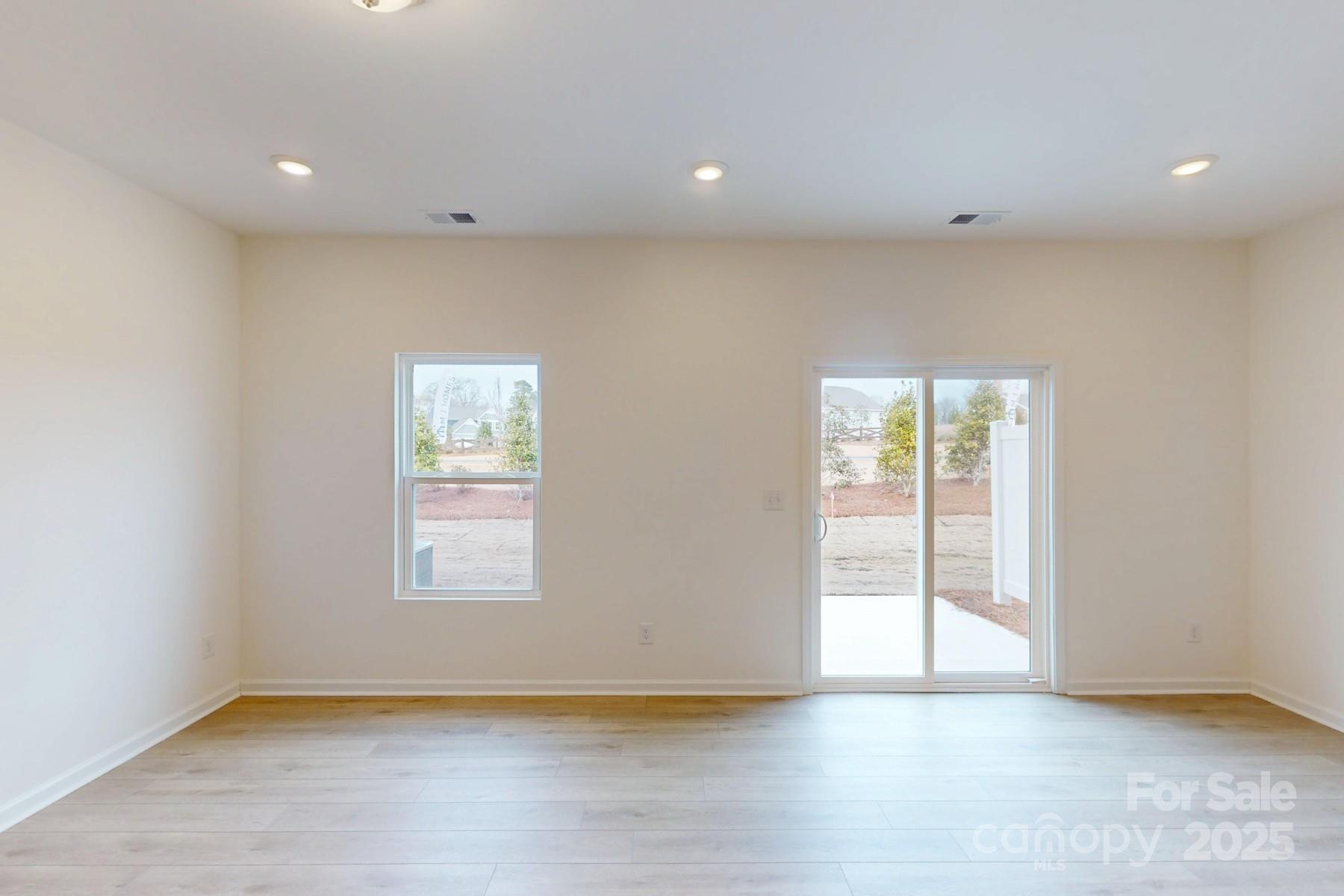 1018 Overbrook Place Wingate, NC 28174 - Photo 9 of 23 an empty room with wooden floor and windows