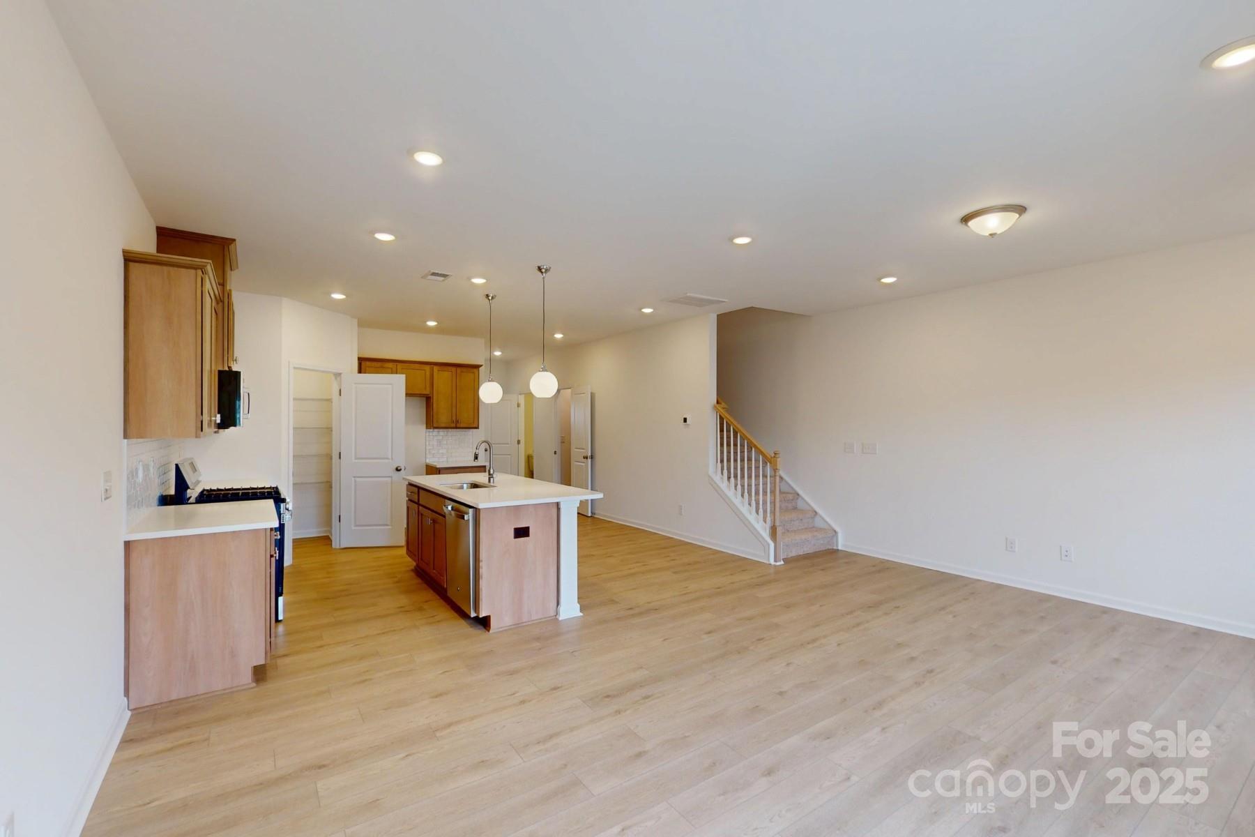 1018 Overbrook Place Wingate, NC 28174 - Photo 10 of 23 a large kitchen with stainless steel appliances kitchen island a large counter top and a wooden floors
