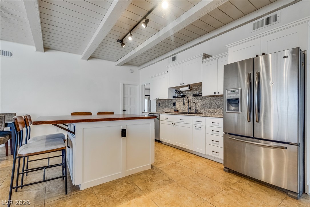 524 Swallow Cove Boulder City, NV 89005 - Photo 15 of 58 A streamlined kitchen offering sleek white cabinetry, granite counters, and modern stainless steel appliances.