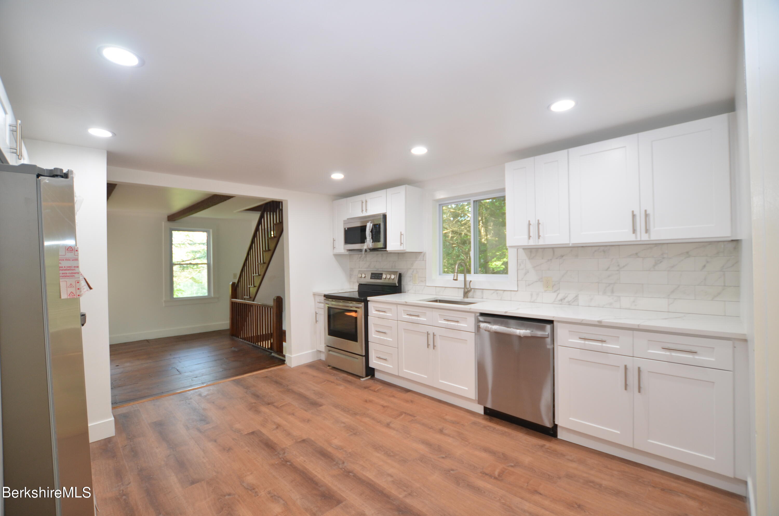 190 Willow Street Lee, MA 01260 - Photo 4 of 41 a kitchen with a sink dishwasher a stove and white cabinets with wooden floor