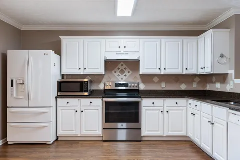 a kitchen with white cabinets and stainless steel appliances