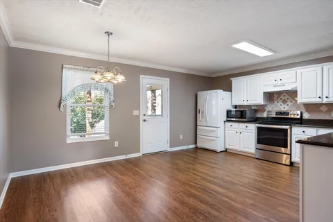 a kitchen with granite countertop stainless steel appliances cabinets and wooden floor