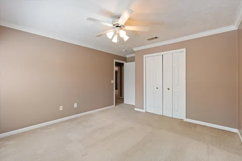 a view of an empty room with chandelier fan