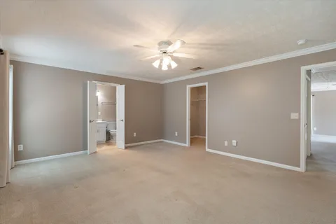 a view of an empty room and chandelier fan