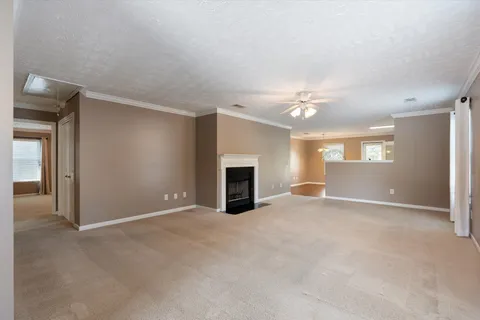 a view of an empty room with a fireplace and a window