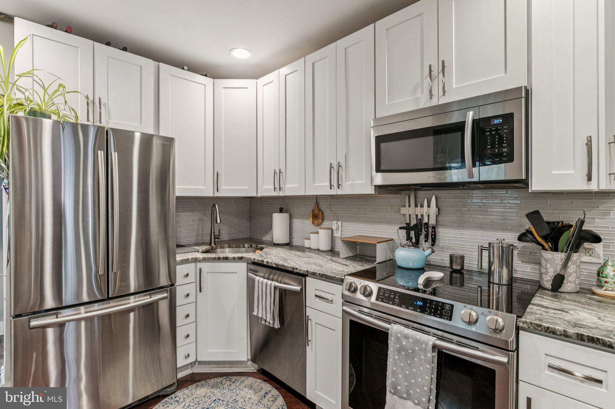 1314 North Dover Street Philadelphia, PA 19121 - Photo 11 of 30 a kitchen with stainless steel appliances granite countertop a stove a refrigerator and a microwave