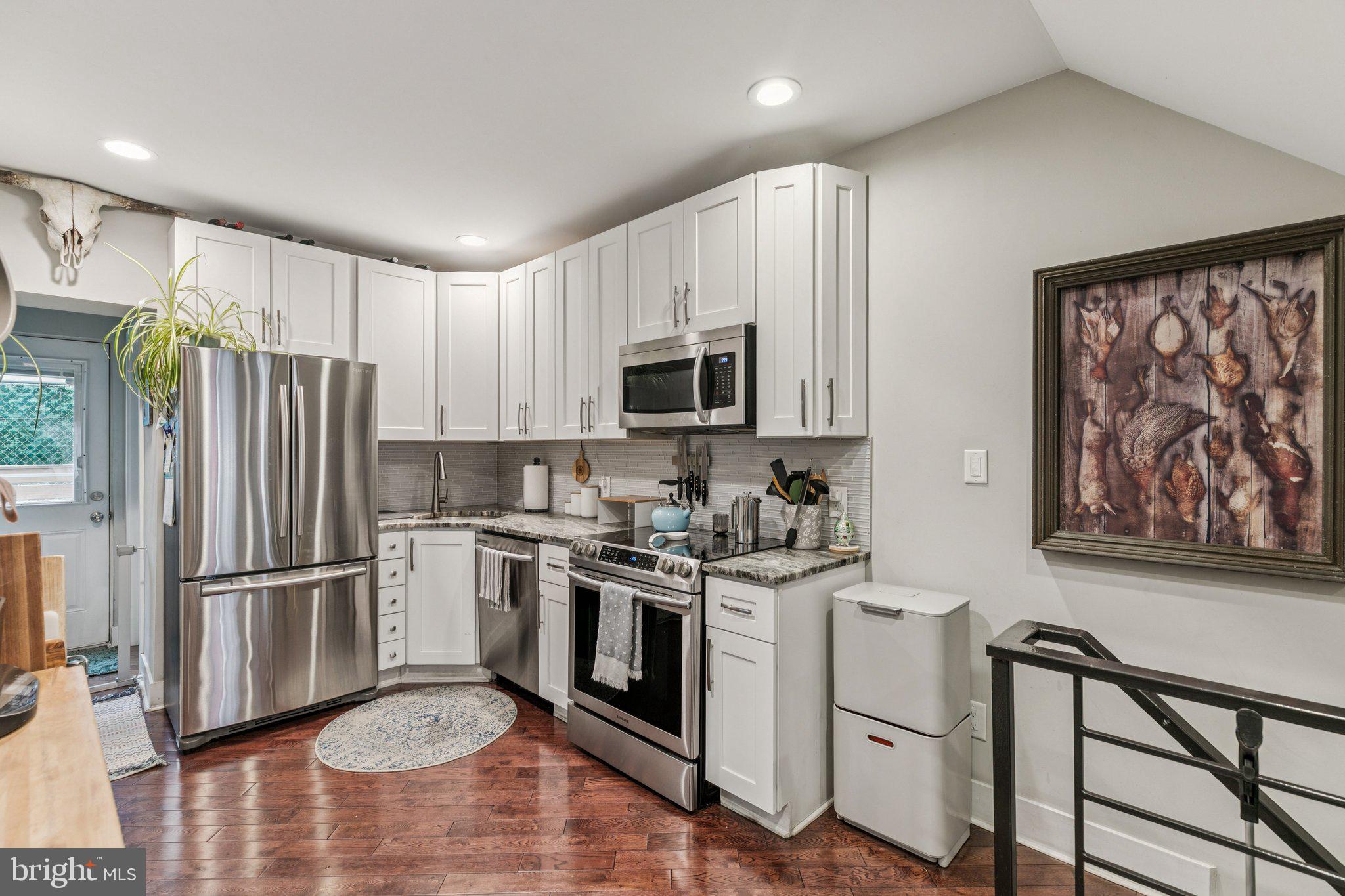 1314 North Dover Street Philadelphia, PA 19121 - Photo 9 of 30 a kitchen with stainless steel appliances granite countertop a stove a refrigerator and a microwave