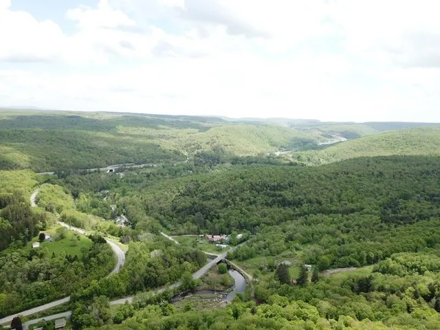 a view of a green field with wooden fence