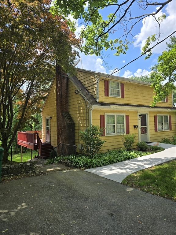 150 Grove Street Reading, MA 01867 - Photo 2 of 20 a front view of a house with yard and trees