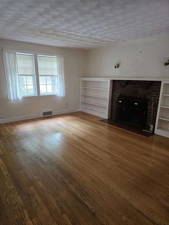 150 Grove Street Reading, MA 01867 - Photo 7 of 20 an empty room with wooden floor and windows
