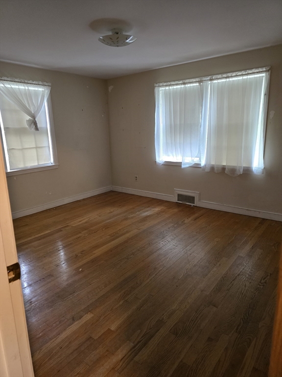 150 Grove Street Reading, MA 01867 - Photo 8 of 20 an empty room with wooden floor and windows