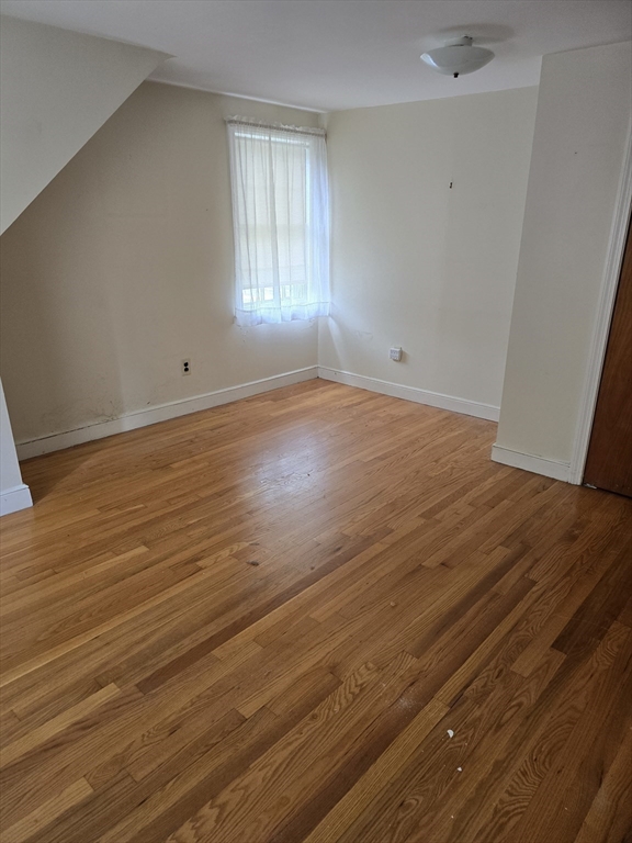 150 Grove Street Reading, MA 01867 - Photo 10 of 20 an empty room with wooden floor and windows