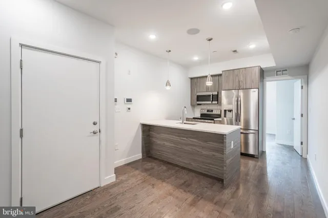 a large kitchen with a refrigerator and a stove