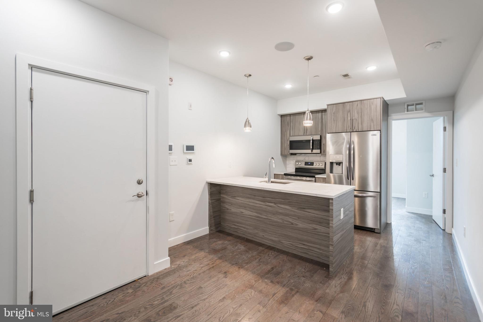 627 West Oxford Street, Unit 2 Philadelphia, PA 19122 - Photo 3 of 14 a large kitchen with a refrigerator and a stove