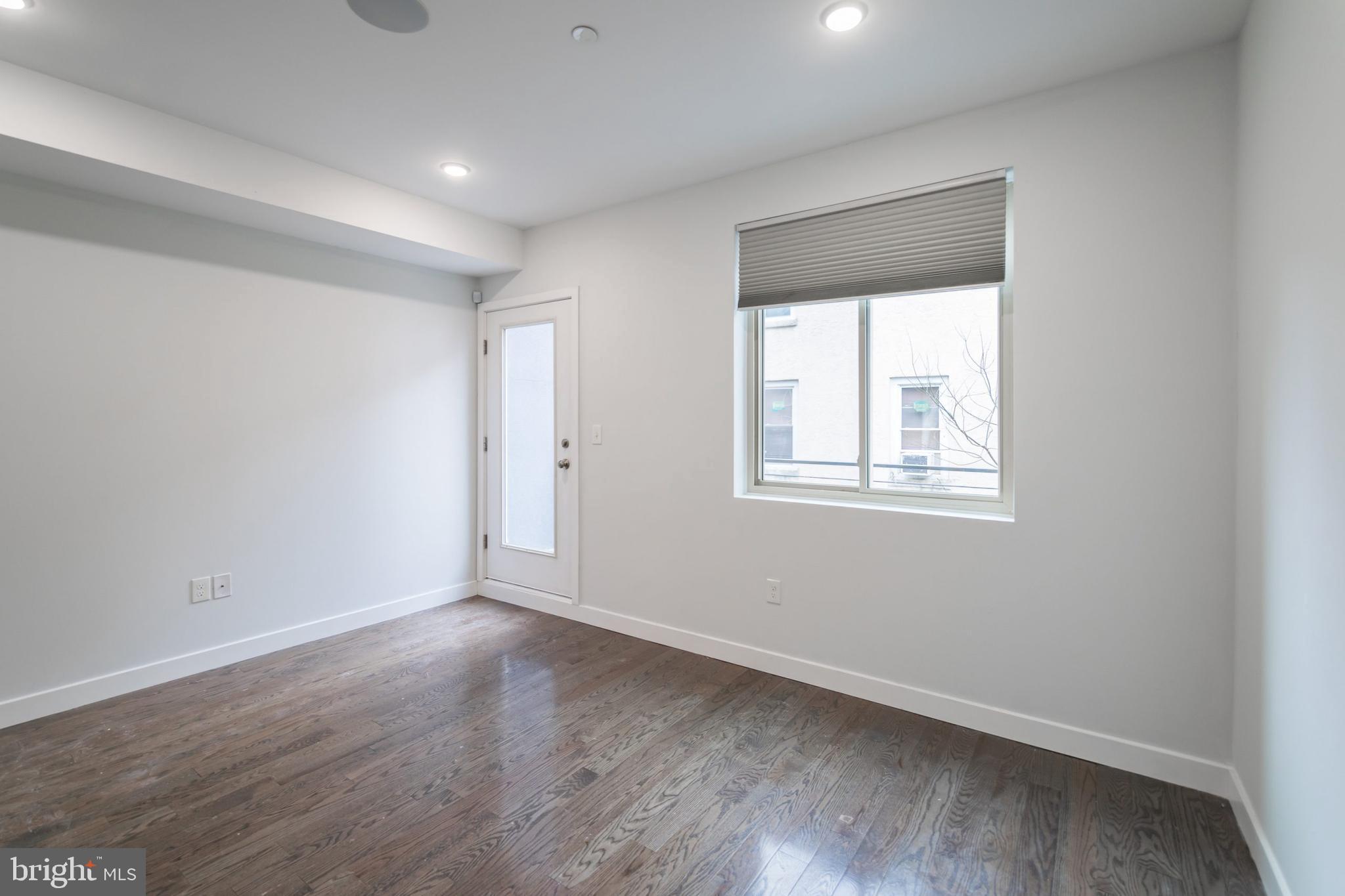 627 West Oxford Street, Unit 2 Philadelphia, PA 19122 - Photo 7 of 14 a view of an empty room with wooden floor and a window