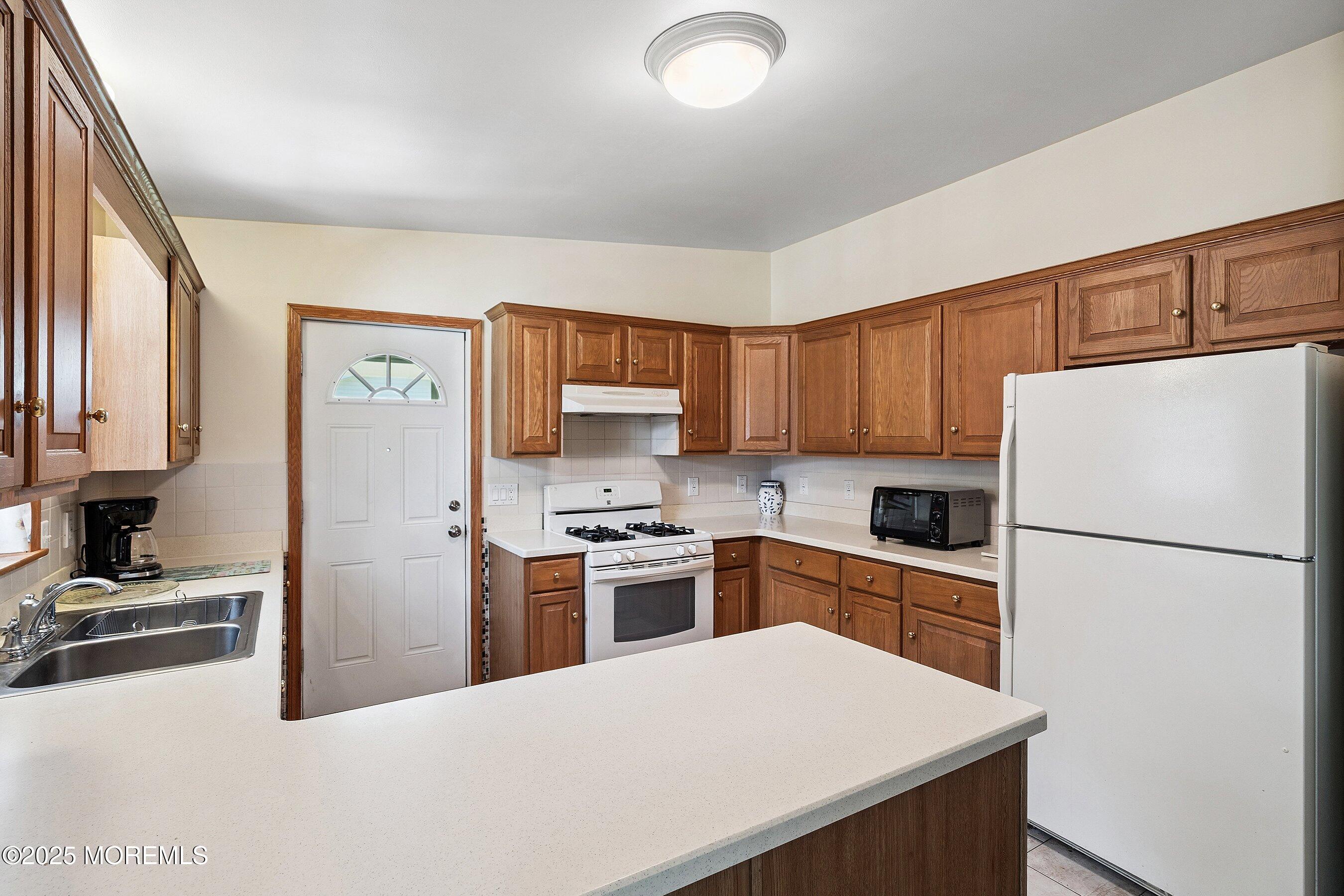 12 Copperfield Drive Cream Ridge, NJ 08514 - Photo 11 of 33 a kitchen with a refrigerator a stove top oven a sink and cabinets