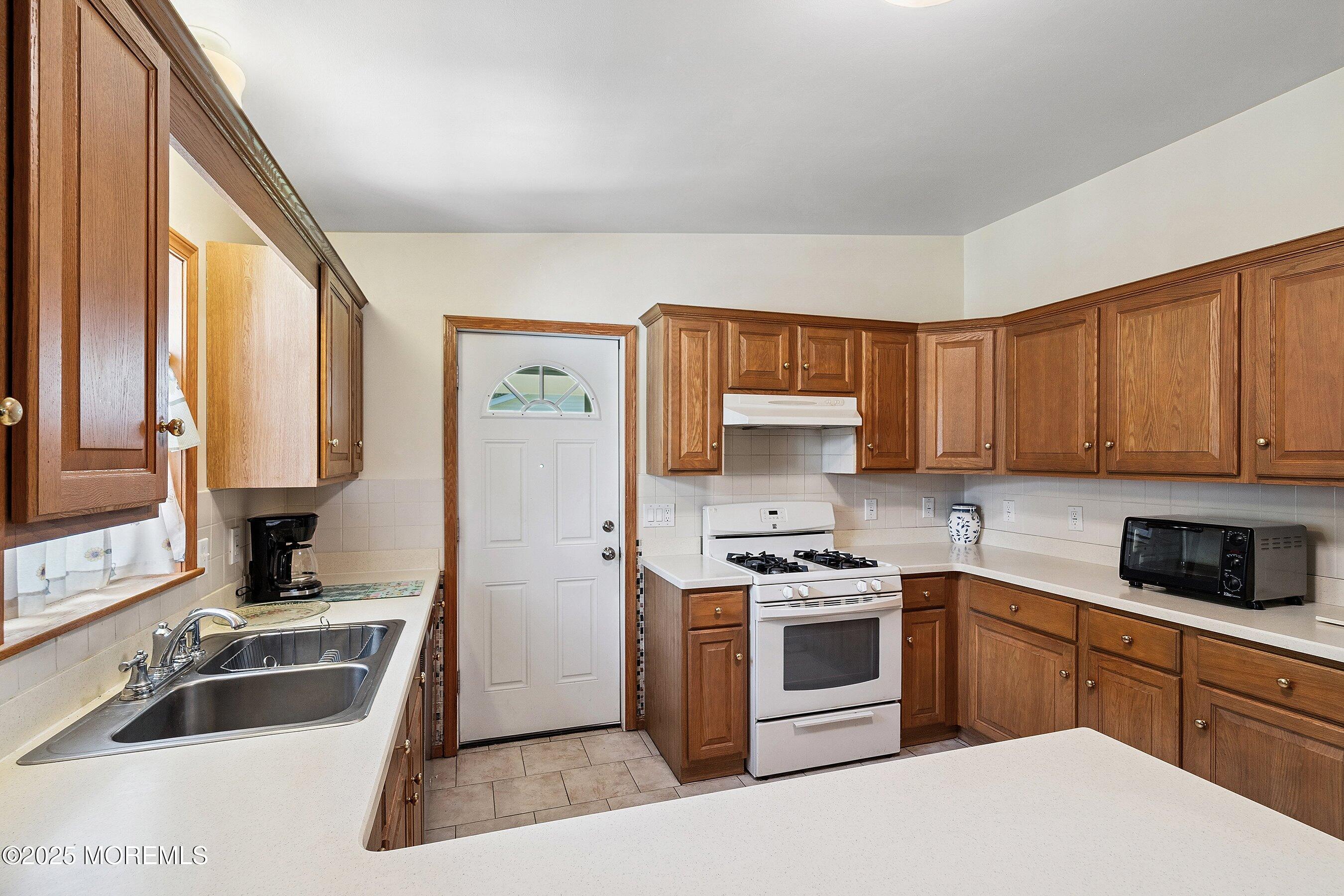 12 Copperfield Drive Cream Ridge, NJ 08514 - Photo 12 of 33 a kitchen with stainless steel appliances granite countertop a sink a stove and a refrigerator with wooden cabinets
