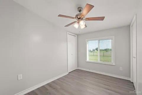 35619 General Brant Road Rio Hondo, TX 78583 - Photo 14 of 21 an empty room with wooden floor fan and windows