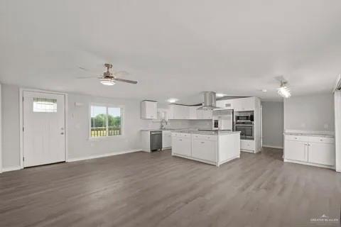 35619 General Brant Road Rio Hondo, TX 78583 - Photo 7 of 21 a large white kitchen with a refrigerator a stove a microwave and furniture