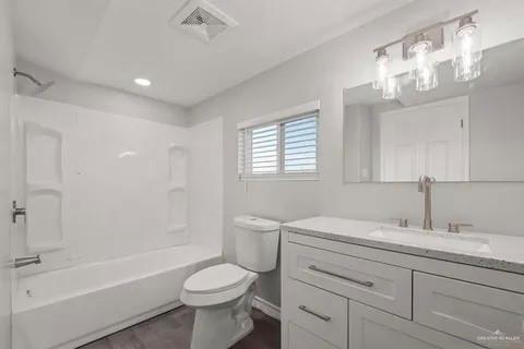 35619 General Brant Road Rio Hondo, TX 78583 - Photo 8 of 21 a bathroom with a toilet a sink a mirror a bathtub and vanity