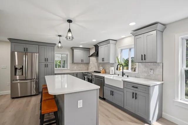 a kitchen with a sink stainless steel appliances and white cabinets