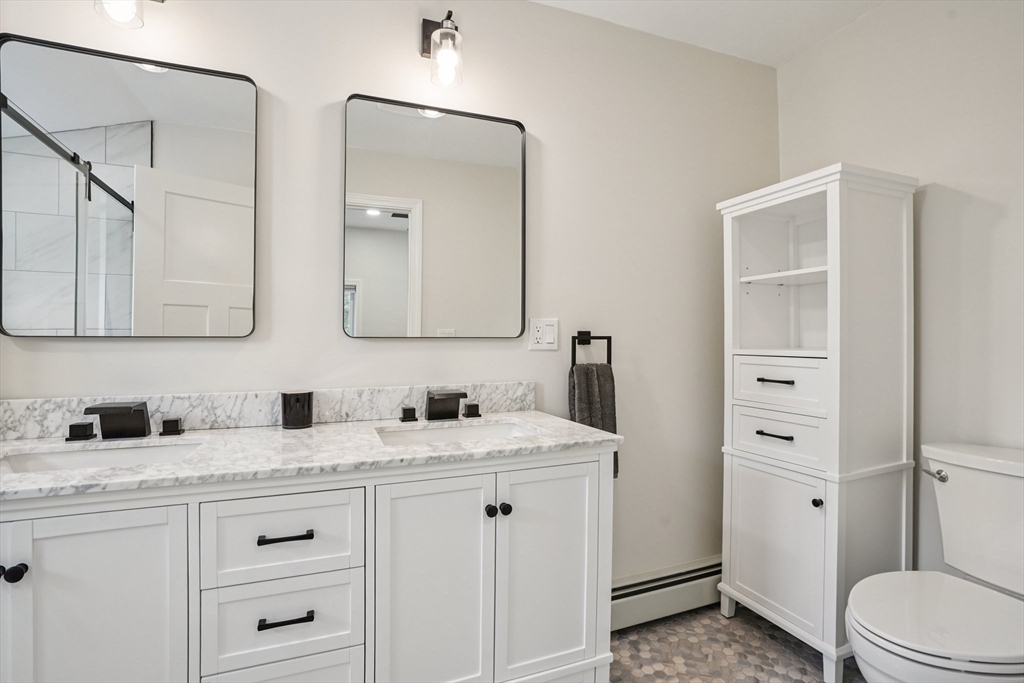 44 Richardson Corner Road Charlton, MA 01507 - Photo 19 of 31 a bathroom with double vanity sink a mirror and a toilet