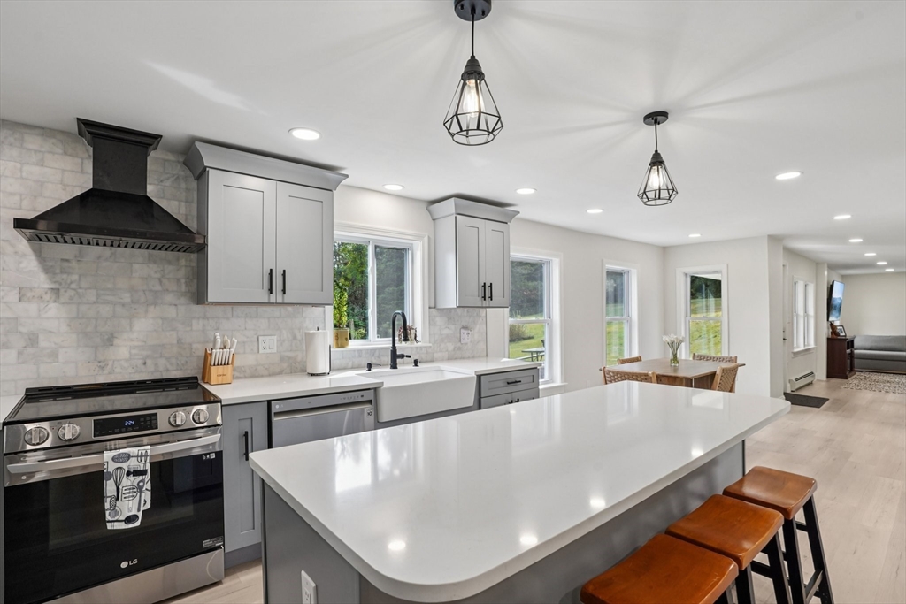 44 Richardson Corner Road Charlton, MA 01507 - Photo 9 of 31 a large kitchen with stainless steel appliances a stove a sink a center island and furniture