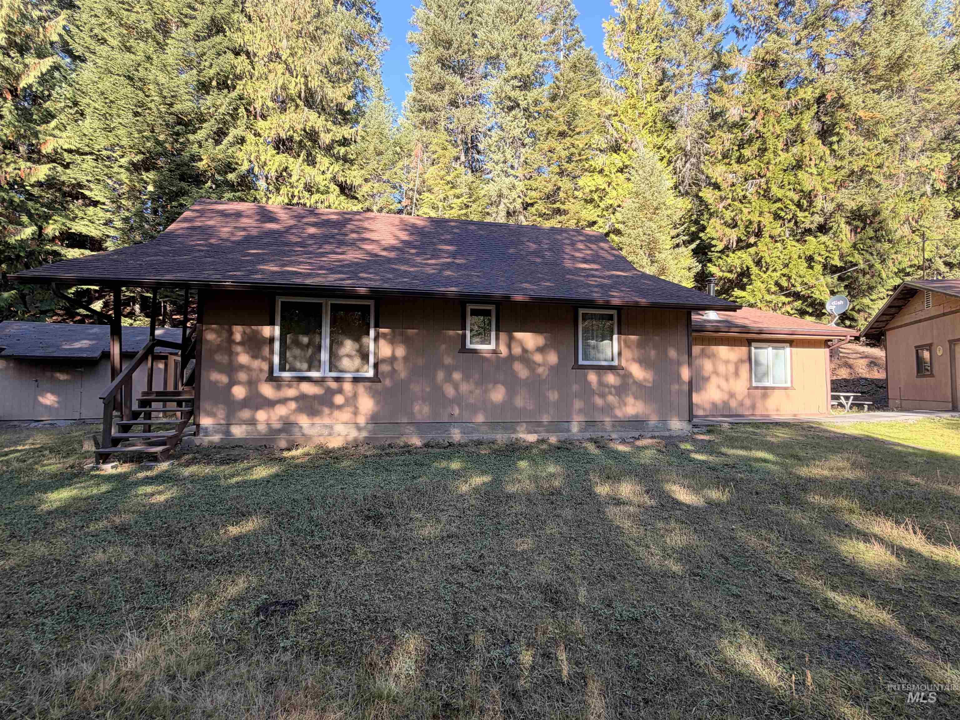 687 Big Cedar Road Kooskia, ID 83539 - Photo 6 of 37 Ranch-style residence featuring a brown shingle roof, wood siding, and white-framed windows