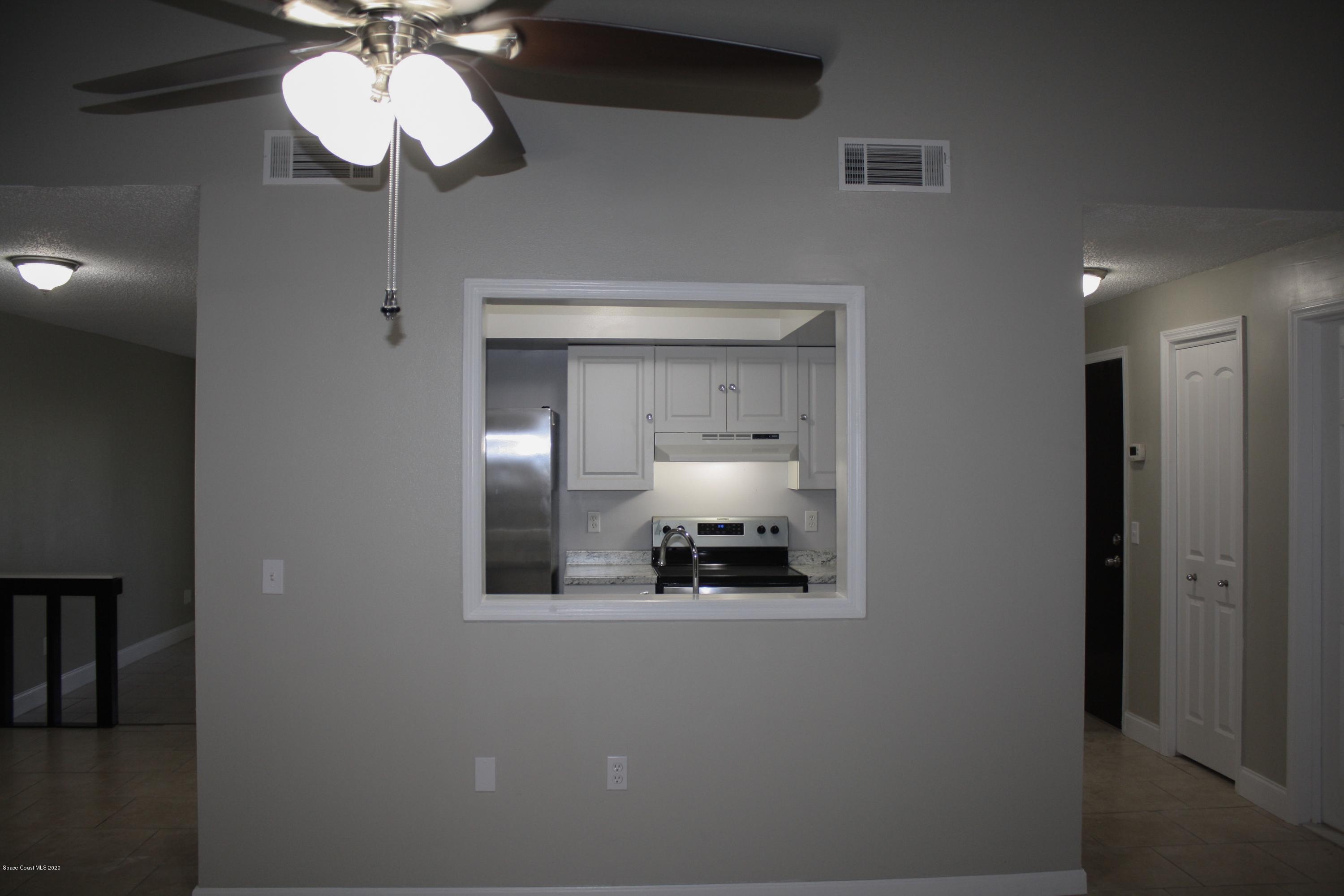 326 Riley Avenue Northeast Palm Bay, FL 32907 - Photo 17 of 43 a view of a hallway with a livingroom and chandelier