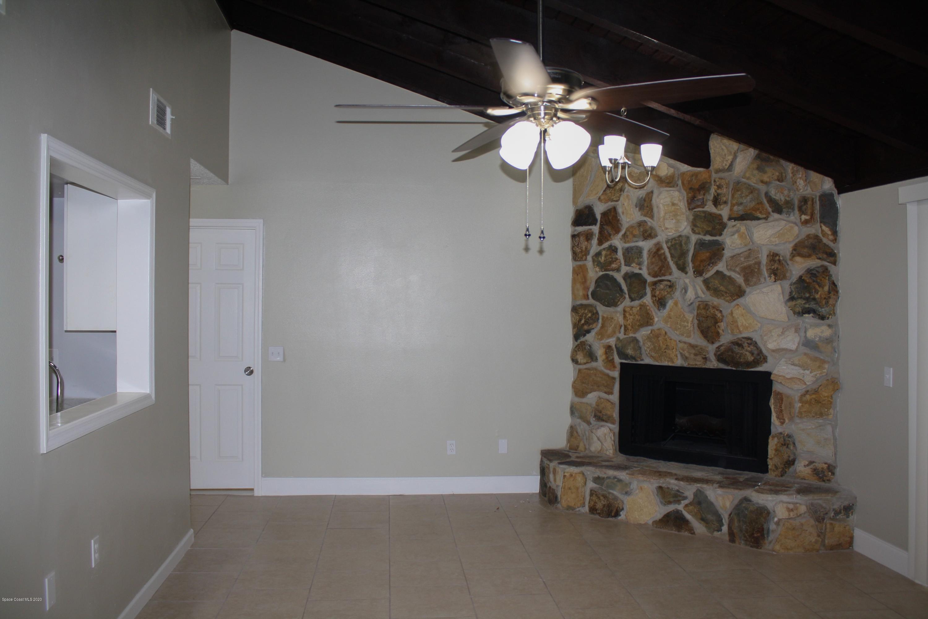 326 Riley Avenue Northeast Palm Bay, FL 32907 - Photo 18 of 43 a view of an empty room with a fireplace and a fan