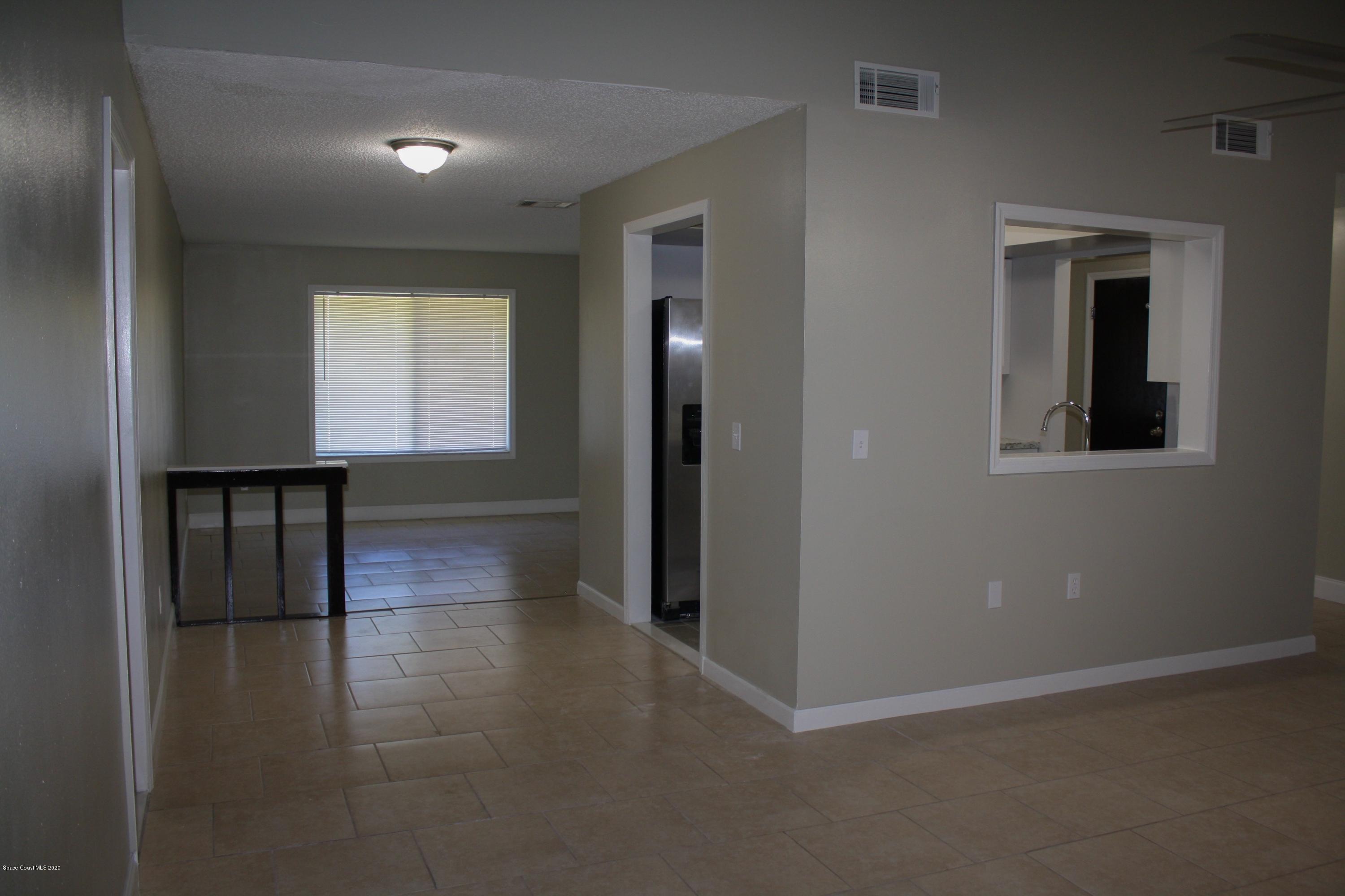 326 Riley Avenue Northeast Palm Bay, FL 32907 - Photo 10 of 43 an empty room with wooden floor and windows