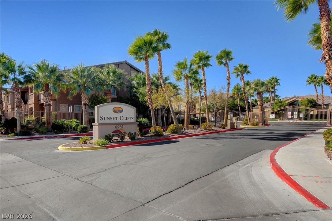 8985 South Durango Drive, Unit 2187 Las Vegas, NV 89113 - Photo 68 of 73 Palm-lined entrance to a secure community, welcoming residents to their serene desert oasis.