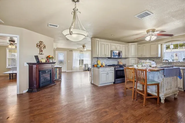 a kitchen with a chandelier and wooden floors
