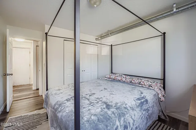 a view of a bedroom with wooden floor and a bathroom