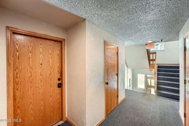 a view of a hallway with closet and stairs