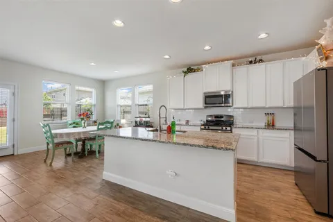 a kitchen with cabinets and wooden floor