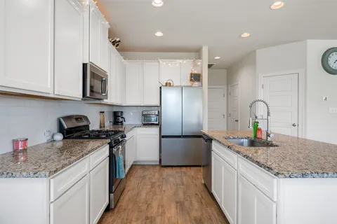 a kitchen with stainless steel appliances granite countertop a sink stove and refrigerator