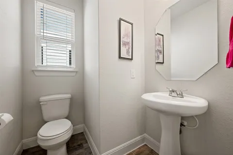 a bathroom with a toilet sink and mirror