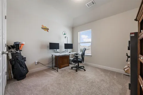 a view of a workspace with furniture and a window
