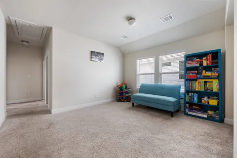 a living room with furniture and a book shelf