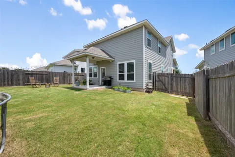 a view of a house with a backyard and a patio