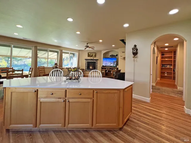 a kitchen with stainless steel appliances granite countertop a sink a stove and a wooden floors
