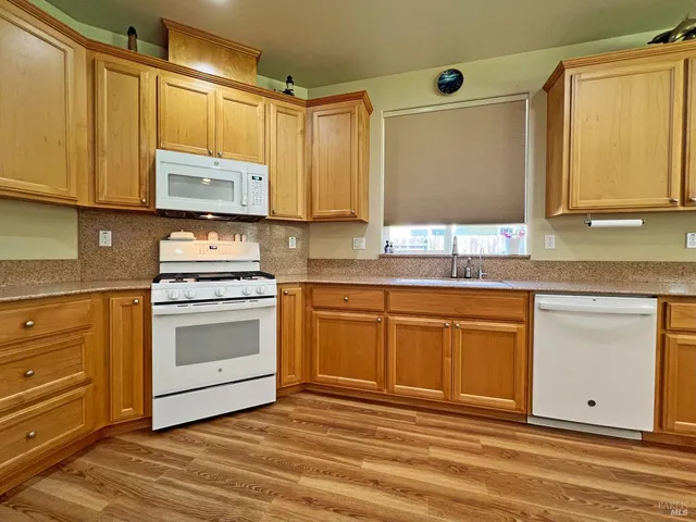 a kitchen with stainless steel appliances granite countertop a sink a stove and a microwave oven