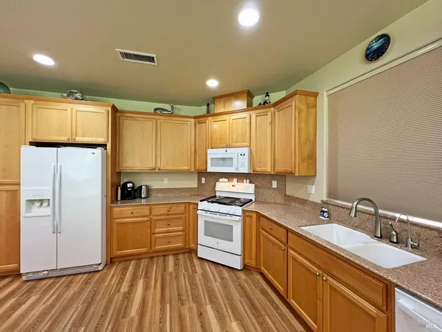 a kitchen with a sink appliances cabinets and a counter top space