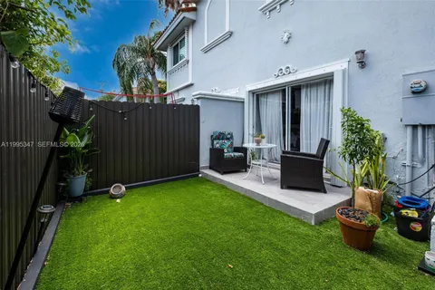 a view of a backyard with furniture potted plants and a wooden fence