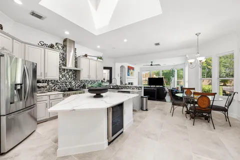 a large white kitchen with a large counter top appliances and cabinets