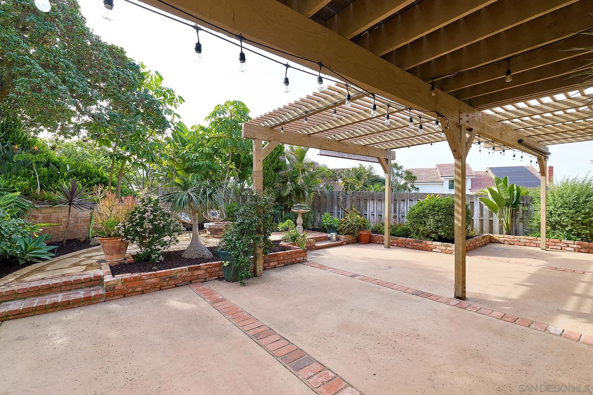 7627 Reposado Drive Carlsbad, CA 92009 - Photo 34 of 54 a view of a patio with table and chairs under an umbrella with a small yard
