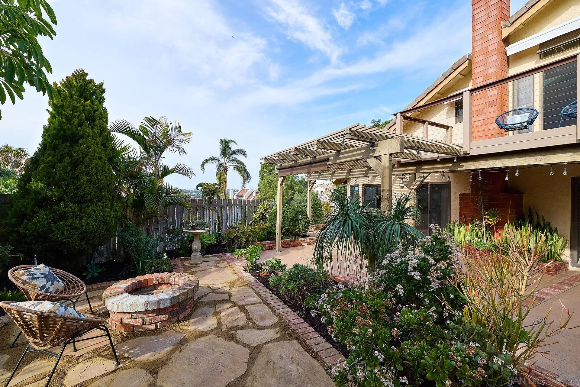 7627 Reposado Drive Carlsbad, CA 92009 - Photo 38 of 54 a backyard of a house with table and chairs and potted plants
