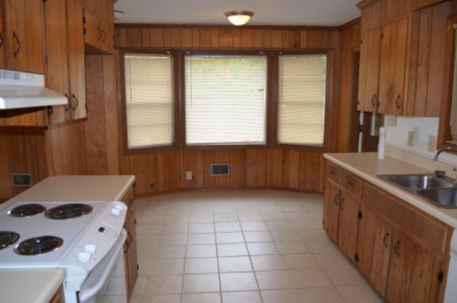 1847 Wood Valley Road Macon, GA 31211 - Photo 6 of 23 a kitchen with a sink a stove and a wooden cabinets